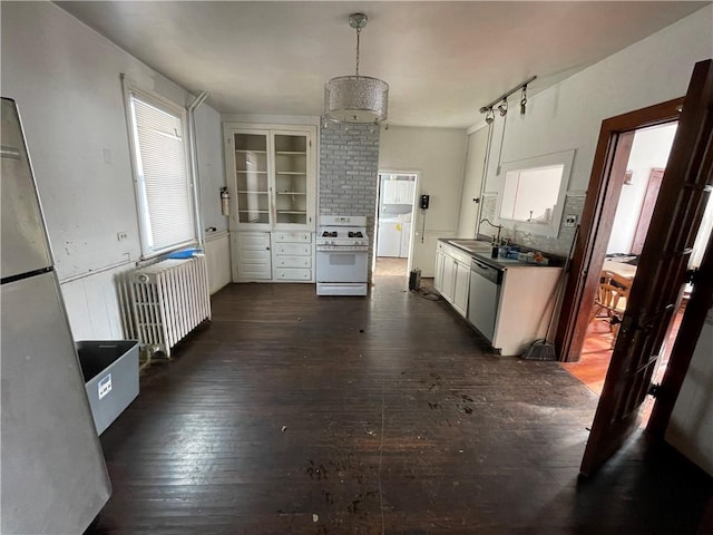 kitchen featuring appliances with stainless steel finishes, radiator, dark wood-type flooring, pendant lighting, and white cabinetry