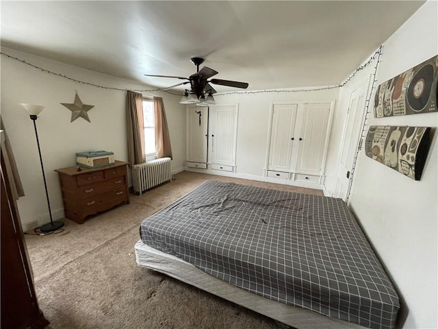 carpeted bedroom featuring ceiling fan and radiator heating unit