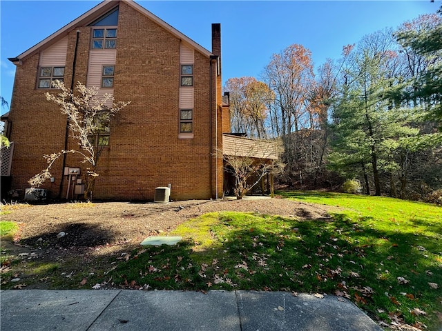 view of home's exterior featuring a lawn and central AC unit