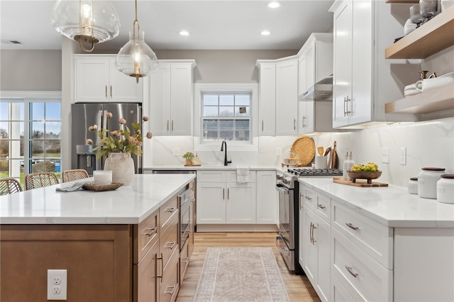 kitchen featuring light stone counters, white cabinets, and stainless steel appliances