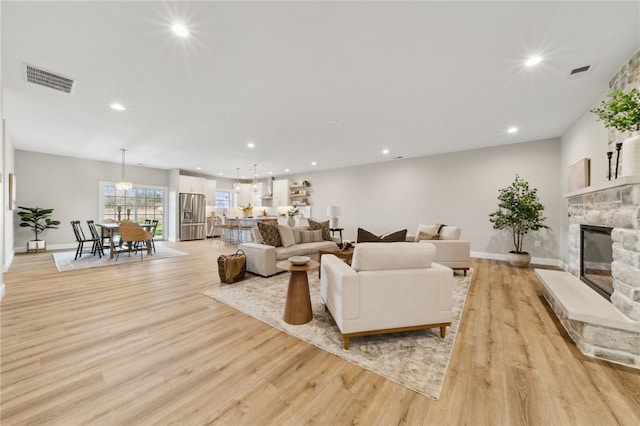 living room with light hardwood / wood-style floors and a fireplace