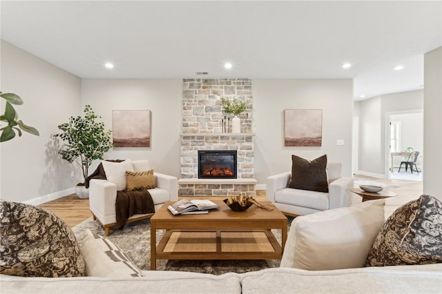 living room featuring hardwood / wood-style flooring and a stone fireplace