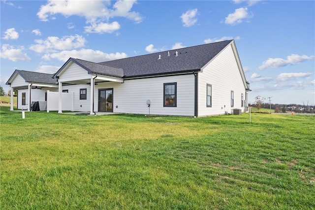 rear view of property featuring a lawn and central air condition unit