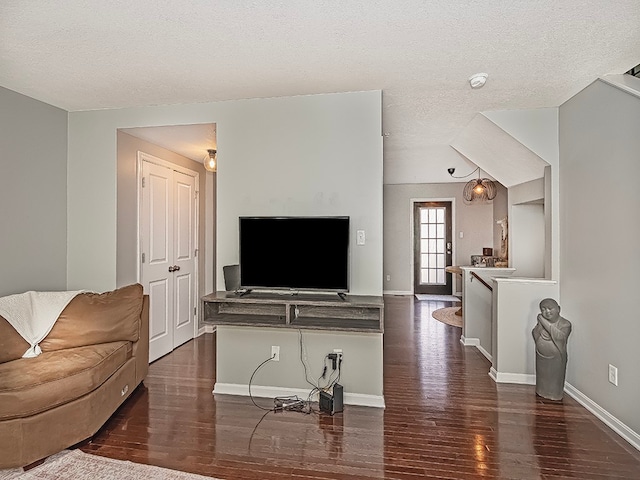 living room with dark wood-type flooring and a textured ceiling