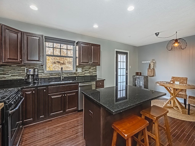 kitchen featuring a kitchen breakfast bar, a kitchen island, stainless steel appliances, and dark wood-type flooring