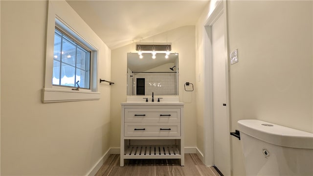 bathroom featuring hardwood / wood-style floors, vanity, lofted ceiling, and toilet