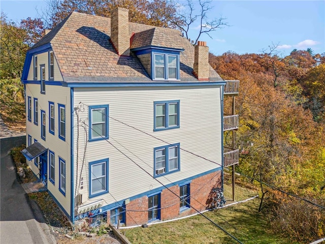 view of property exterior with a balcony and a yard