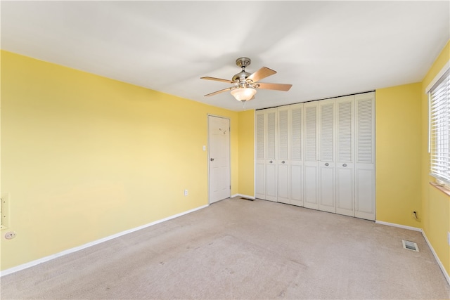 unfurnished bedroom with ceiling fan and light carpet