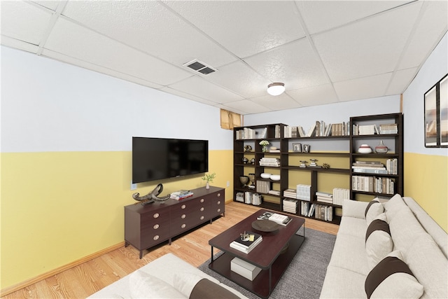 living room with a paneled ceiling and wood-type flooring