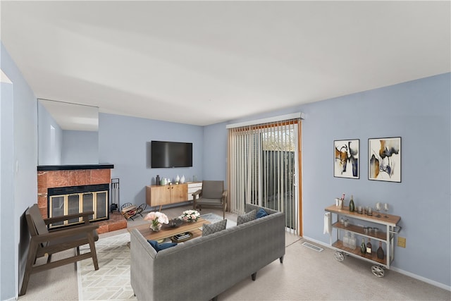 living room with light carpet and a tiled fireplace