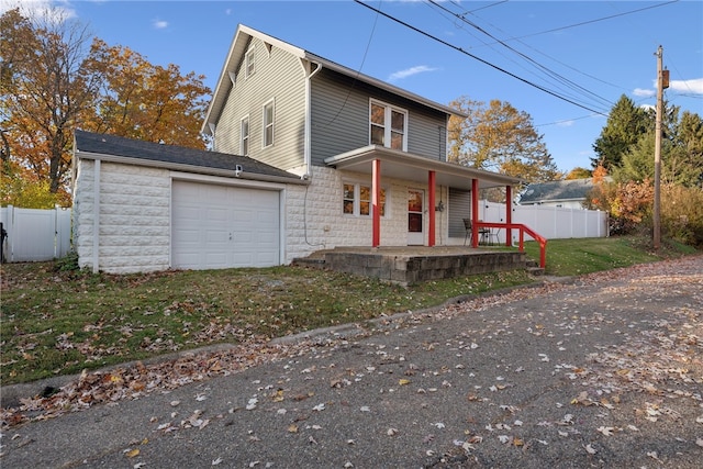 view of front of house with a front lawn, a porch, and a garage