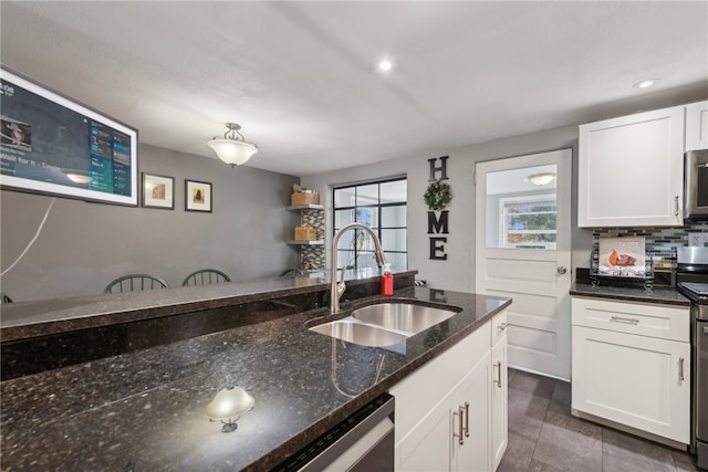 kitchen featuring white cabinets, sink, decorative backsplash, dark stone countertops, and dark tile patterned floors