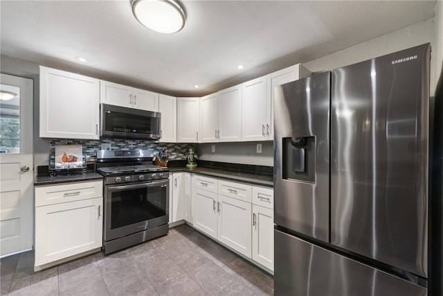 kitchen with decorative backsplash, white cabinets, light tile patterned floors, and appliances with stainless steel finishes