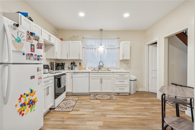 kitchen with white appliances, sink, pendant lighting, light hardwood / wood-style flooring, and white cabinets