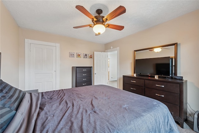 bedroom with carpet, ceiling fan, and a textured ceiling