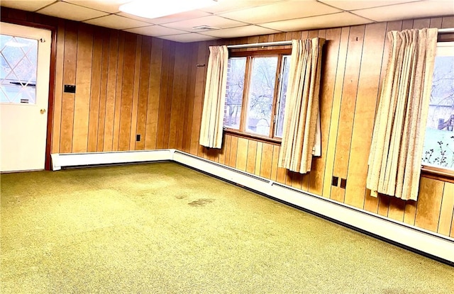 interior space featuring wood walls and a drop ceiling