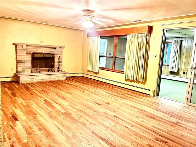 unfurnished living room featuring ceiling fan, a fireplace, and a baseboard radiator