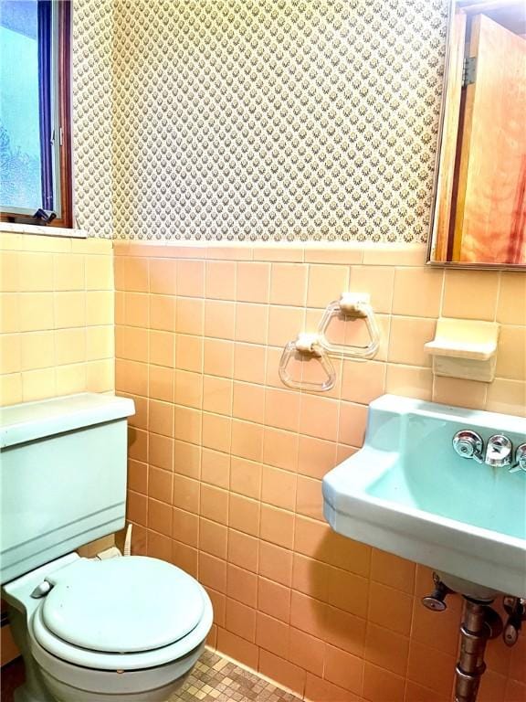 bathroom featuring toilet and tile walls