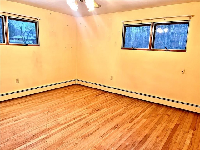 spare room featuring a baseboard radiator and light hardwood / wood-style flooring