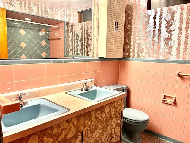 bathroom with vanity, tile walls, and toilet