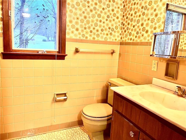 bathroom with vanity, tile walls, and toilet