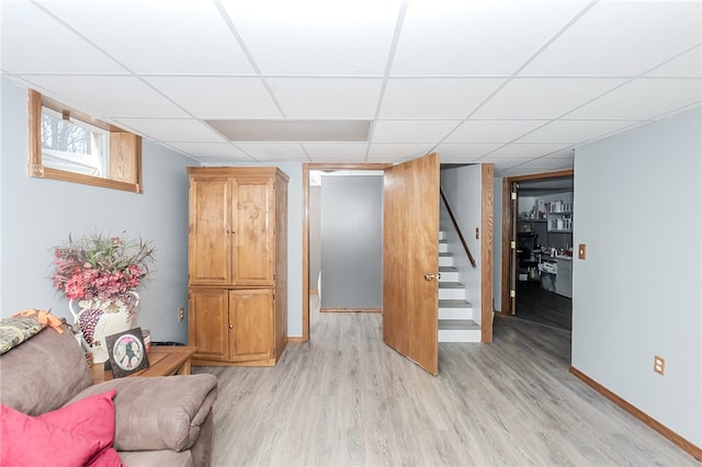 interior space featuring a drop ceiling and light hardwood / wood-style floors