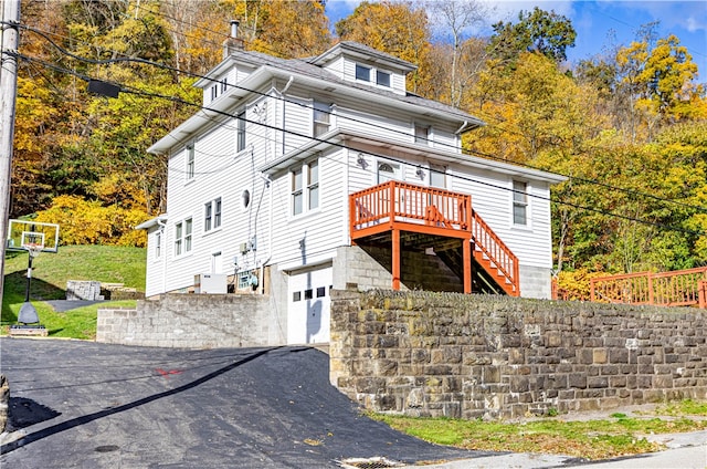 exterior space featuring a garage and a wooden deck