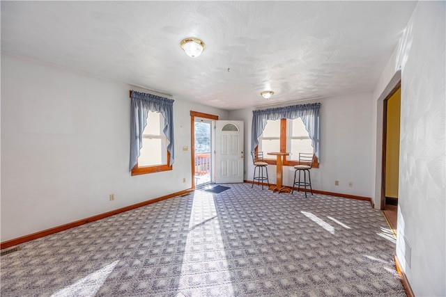 carpeted entrance foyer with a healthy amount of sunlight