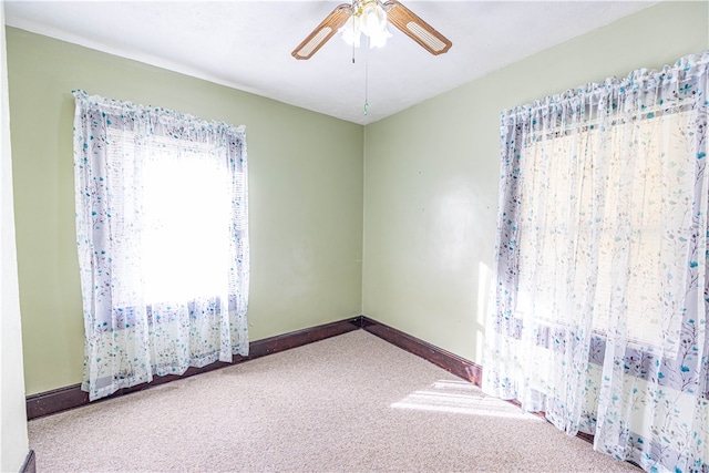 carpeted empty room featuring ceiling fan