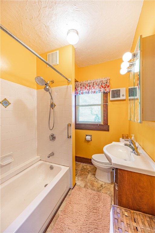 full bathroom featuring tiled shower / bath combo, toilet, and vanity