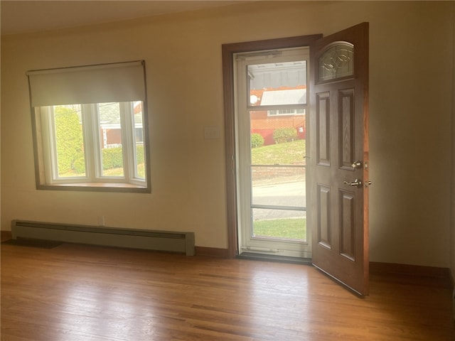 doorway with baseboard heating, a healthy amount of sunlight, and light wood-type flooring