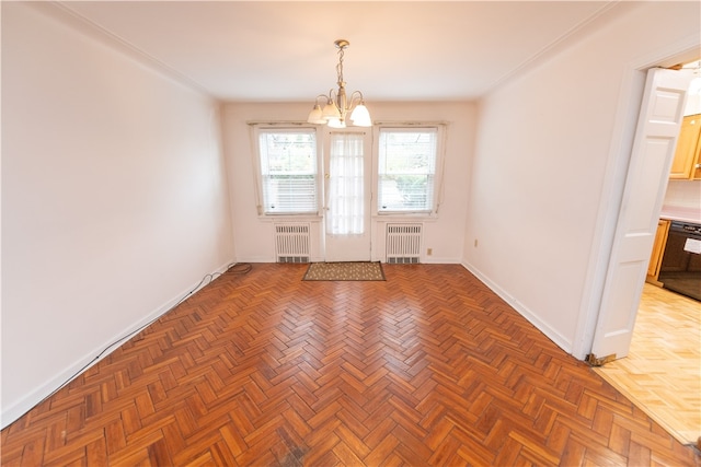 unfurnished room with parquet flooring, radiator, and a chandelier