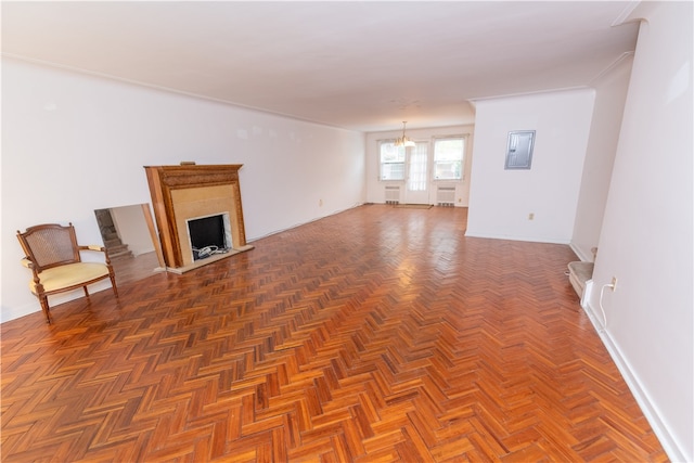 unfurnished living room with a notable chandelier, dark parquet floors, and electric panel