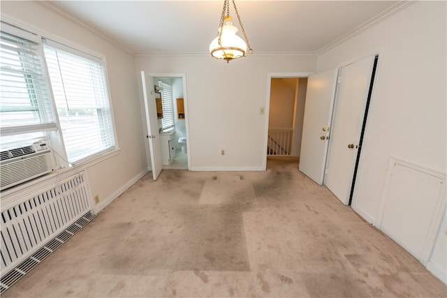 carpeted spare room featuring radiator and crown molding