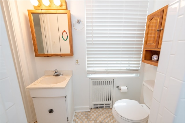 bathroom with radiator heating unit, vanity, and toilet