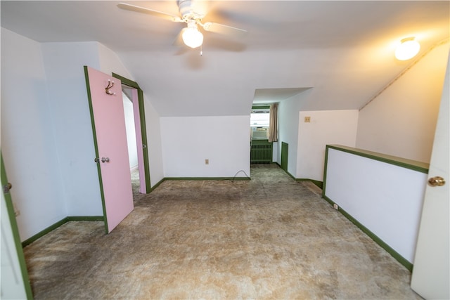 bonus room featuring light carpet, radiator heating unit, ceiling fan, and vaulted ceiling