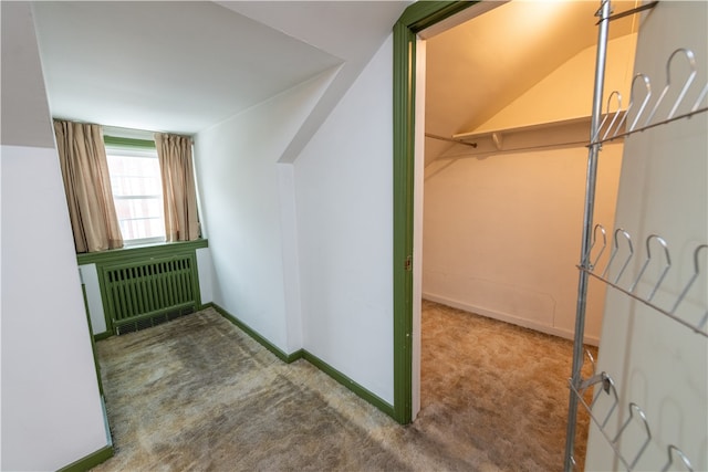 additional living space with carpet flooring, radiator, and vaulted ceiling