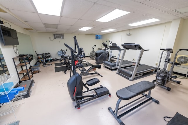 exercise room with a paneled ceiling and concrete flooring