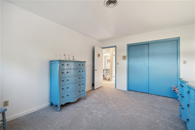 unfurnished bedroom featuring light colored carpet and a closet