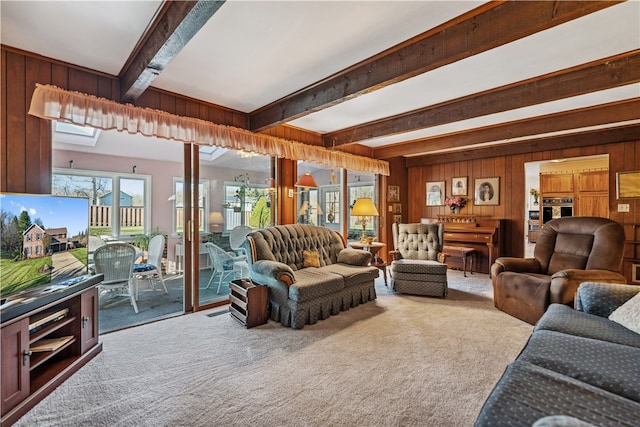 carpeted living room featuring wooden walls and beamed ceiling