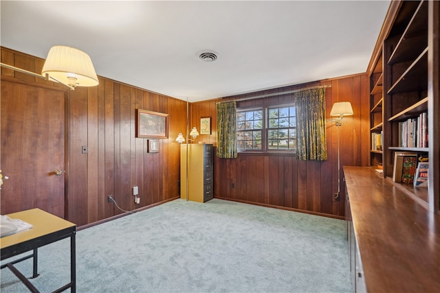 interior space with light carpet and wooden walls