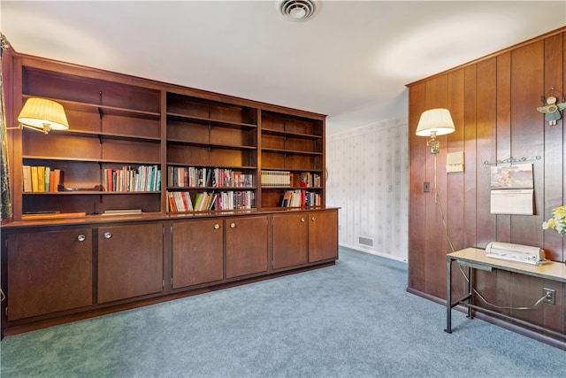 interior space with light carpet and wooden walls