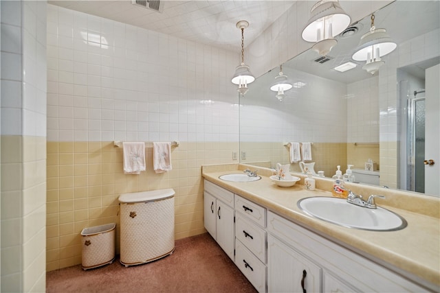 bathroom with vanity, an enclosed shower, and tile walls