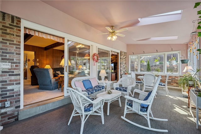 sunroom / solarium featuring lofted ceiling with skylight and ceiling fan