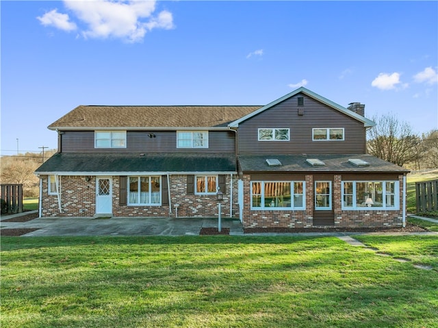 rear view of property with a lawn and a patio area