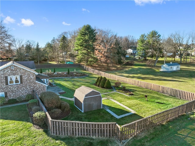 view of property's community featuring a lawn and an outbuilding