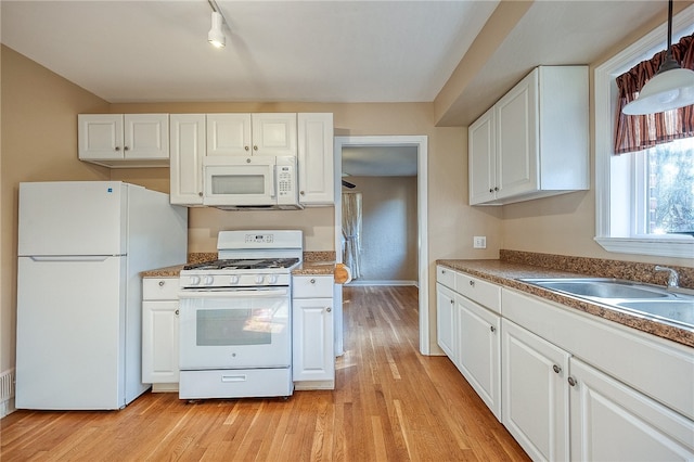 kitchen featuring light wood-type flooring, rail lighting, white appliances, sink, and white cabinets