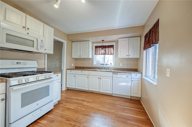 kitchen with white cabinets, white appliances, and a wealth of natural light