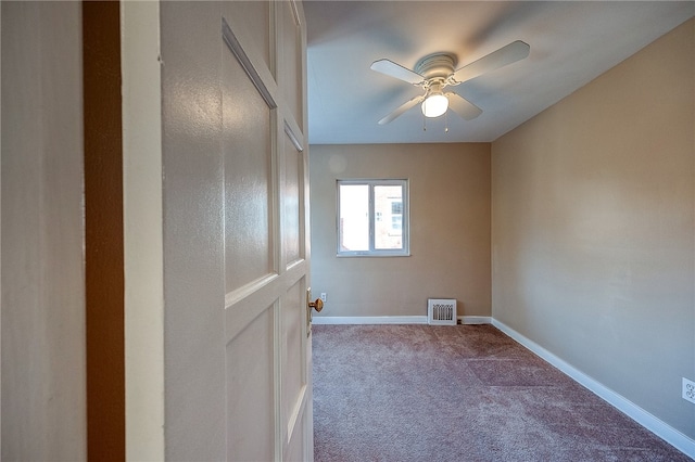 carpeted spare room featuring ceiling fan