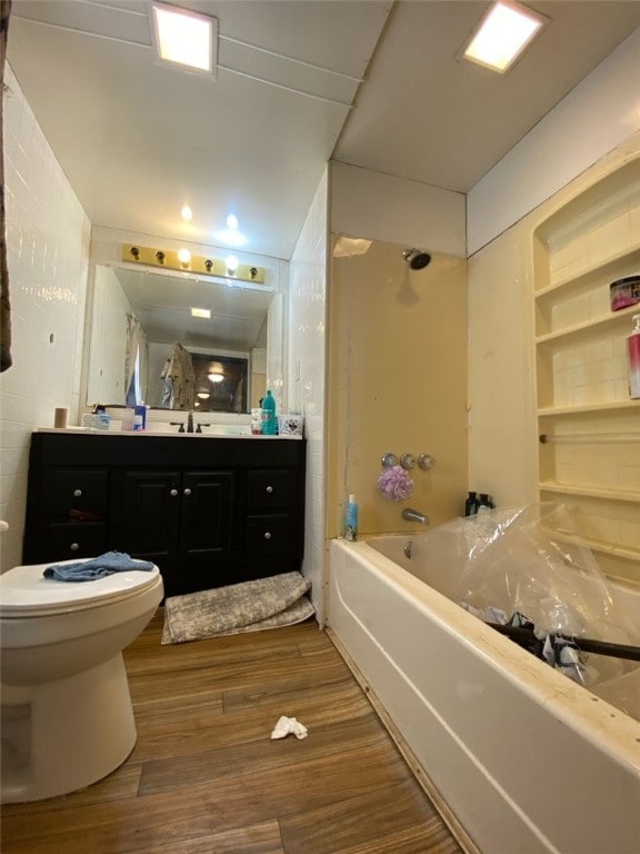 full bathroom with vanity,  shower combination, built in features, hardwood / wood-style floors, and toilet